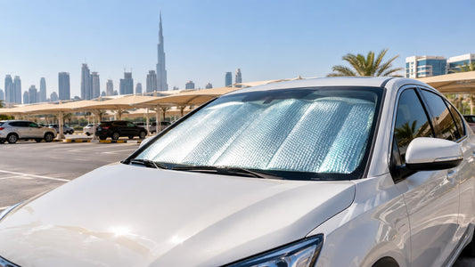 Car parked in bright sunlight in a Dubai car park with a reflective sun shade fitted inside the windscreen
